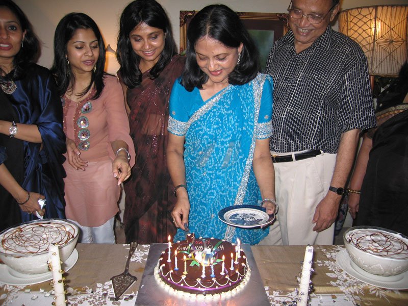 Ammu cutting her birthday cake, with Kimu, Nadia, me, and Abbu around her
