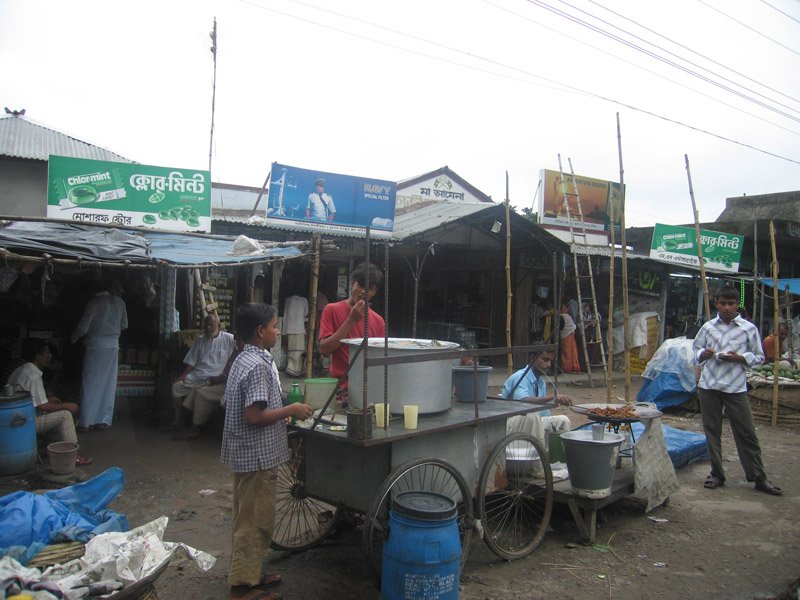 cooking food at a food-cart in a village market by the side of the highway
