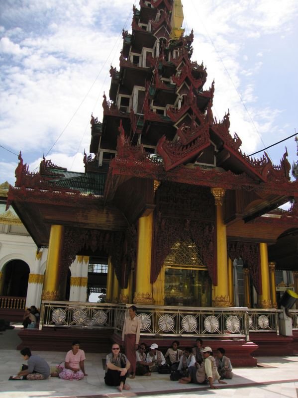 chuck resting in the shade of a temple with some devotees
