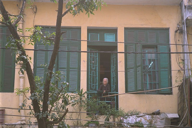 little old lady watching the street life below from her balcony
